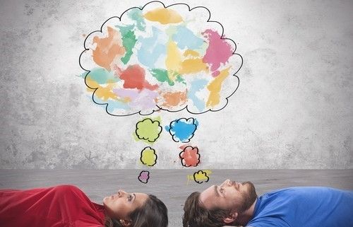 imagen de un hombre y una mujer acostados en el piso, boca arriba y una ilustración de un globo de pensamientos compartidos, son manchas de colores