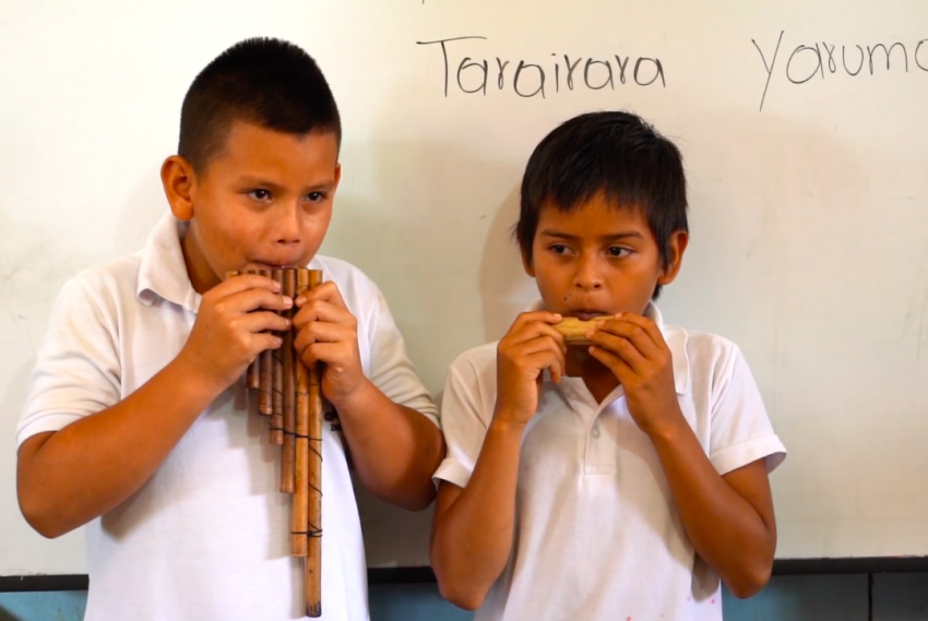 Estudiantes tocando instrumento musical ancestral