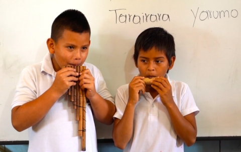 Estudiantes tocando instrumento musical ancestral